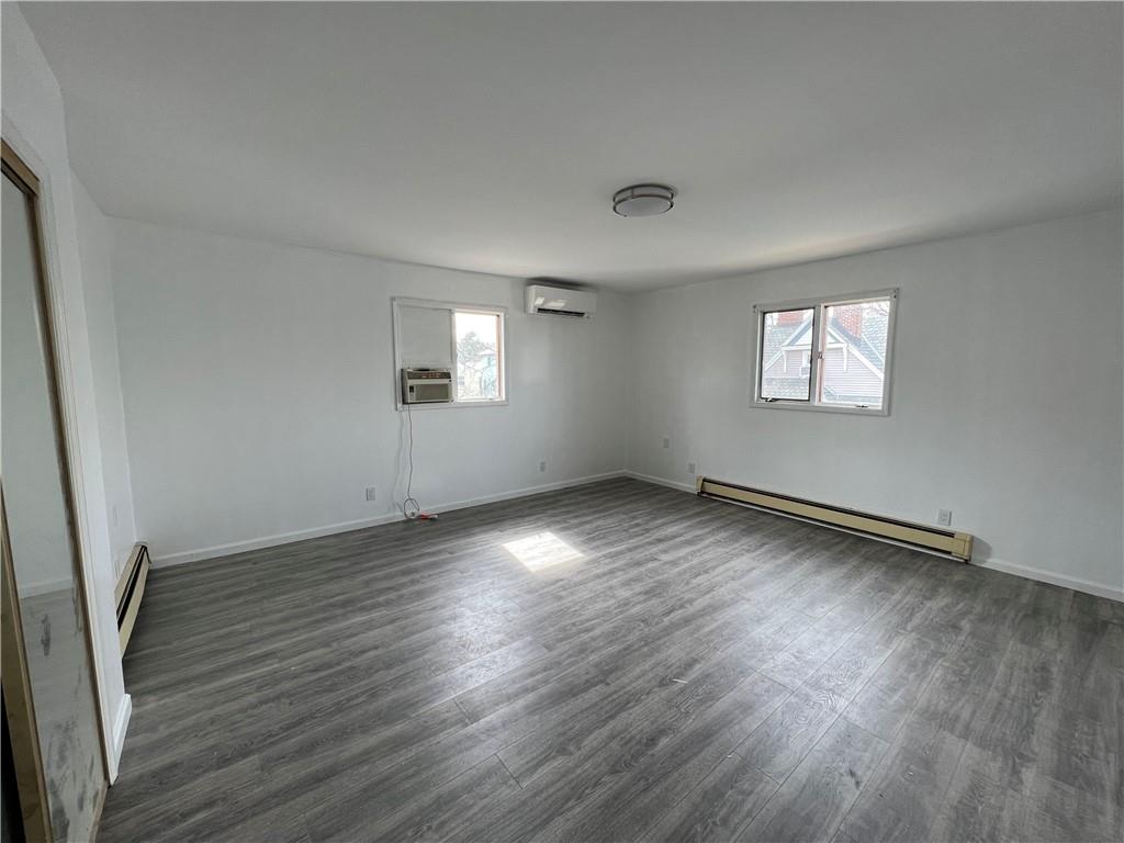 212 Manor Road Staten Island, NY 10314 - Photo 8 of 12 an empty room with wooden floor and windows