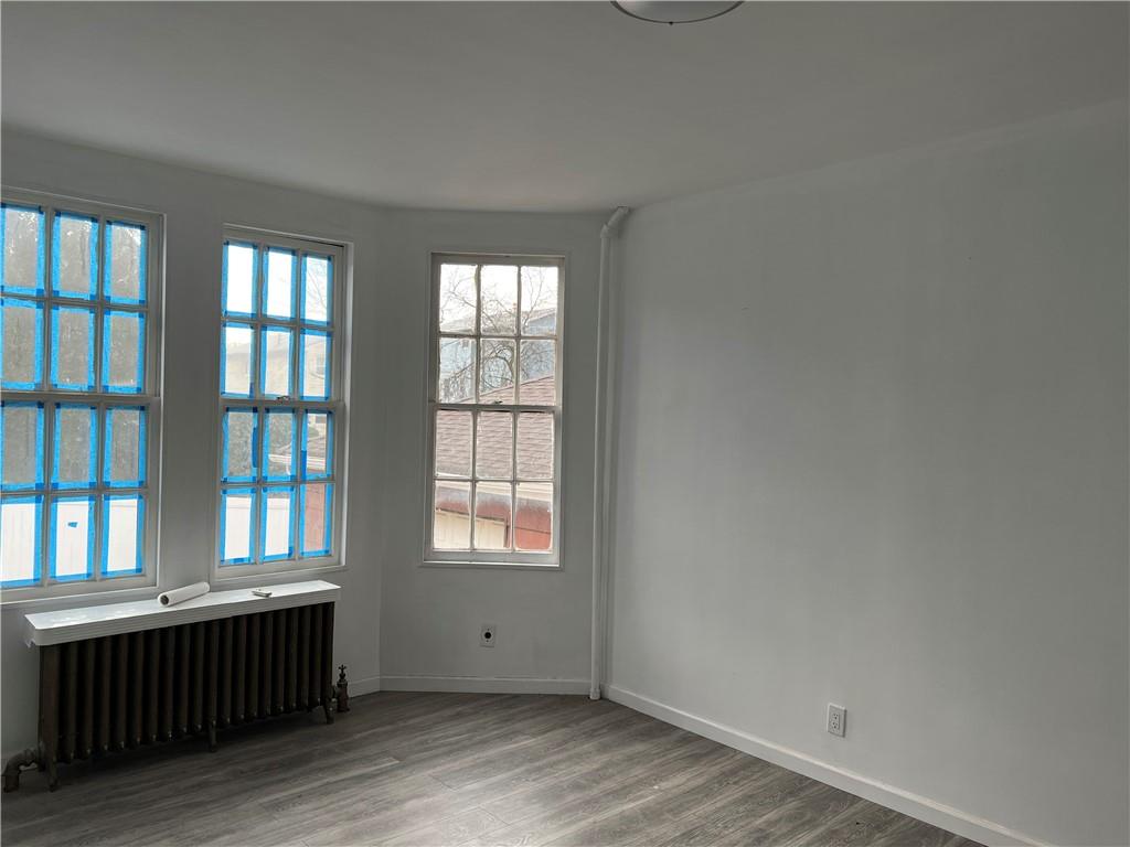 212 Manor Road Staten Island, NY 10314 - Photo 10 of 12 an empty room with wooden floor and windows