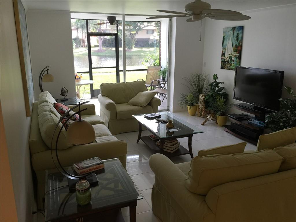 3670 Inverrary Drive, Unit 1E Lauderhill, FL 33319 - Photo 2 of 15 a living room with furniture and a flat screen tv