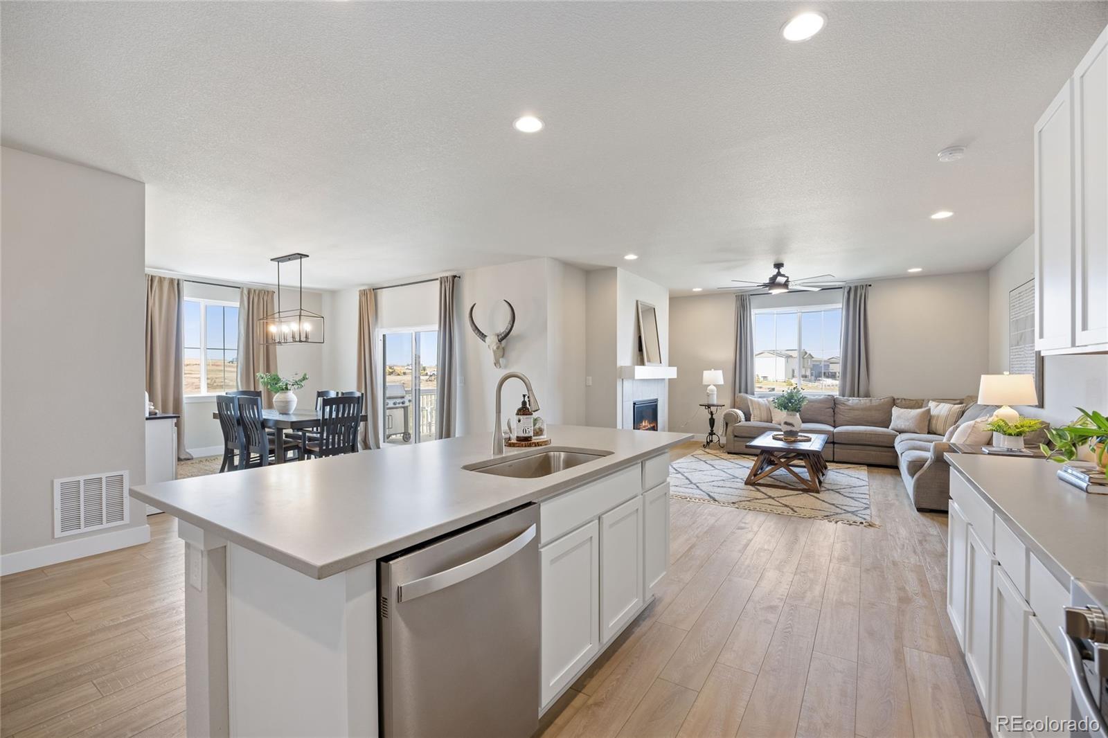 12649 Buffington Trail Parker, CO 80134 - Photo 11 of 47 a large kitchen with kitchen island a large counter top space a sink stainless steel appliances and cabinets