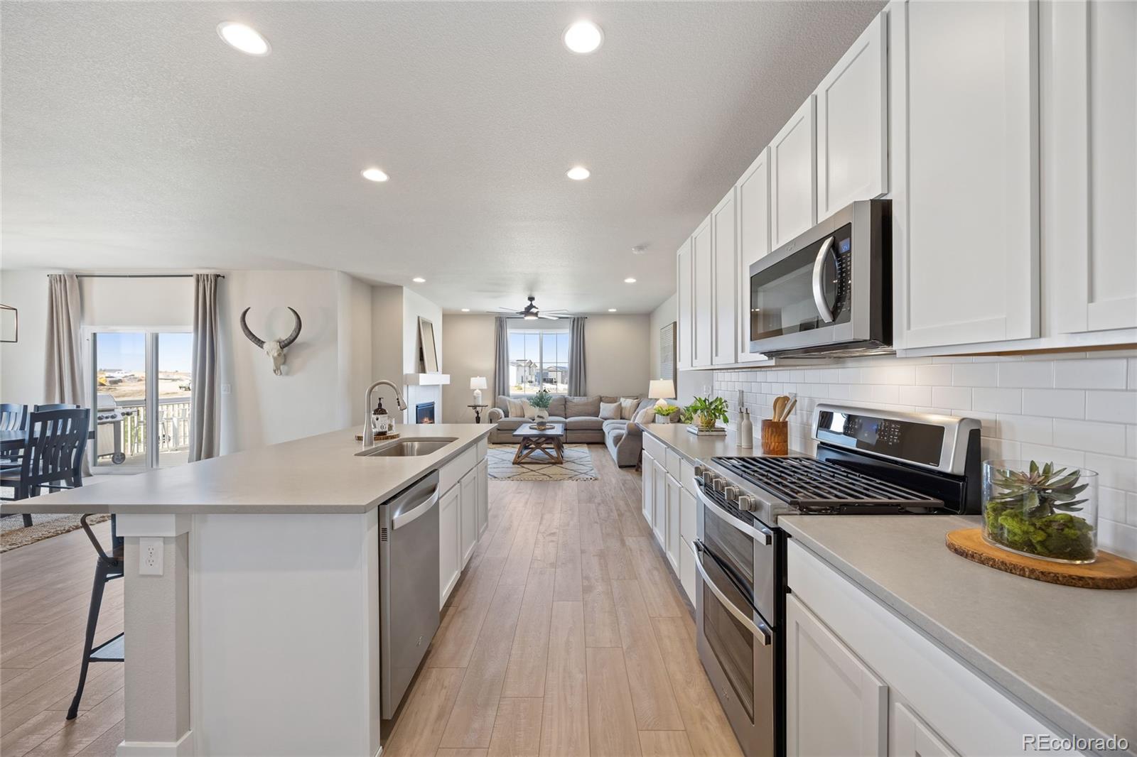 12649 Buffington Trail Parker, CO 80134 - Photo 12 of 47 a kitchen with counter top space a sink a stove and cabinets