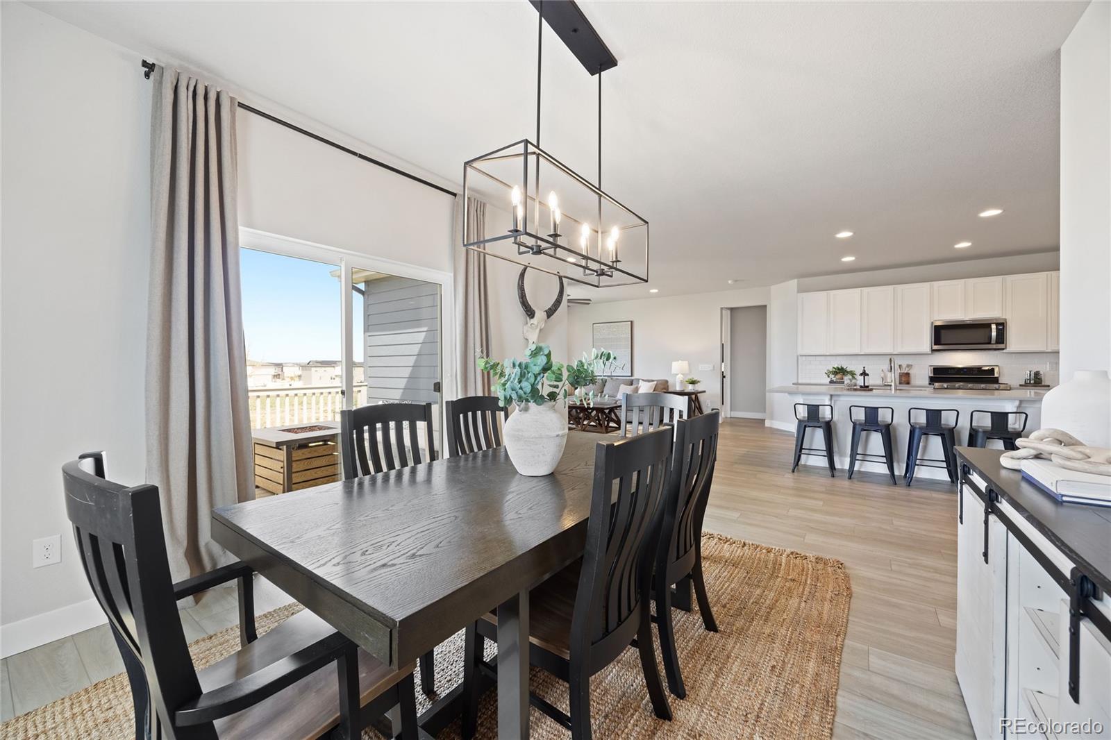 12649 Buffington Trail Parker, CO 80134 - Photo 16 of 47 a view of a dining room and livingroom with furniture wooden floor a chandelier