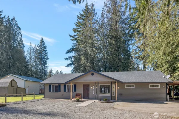a front view of a house with a garden and tree