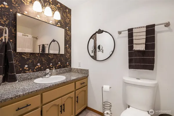 a bathroom with a toilet a sink and a mirror