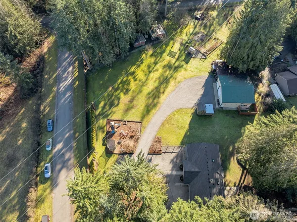 an aerial view of a house with a yard and a large tree