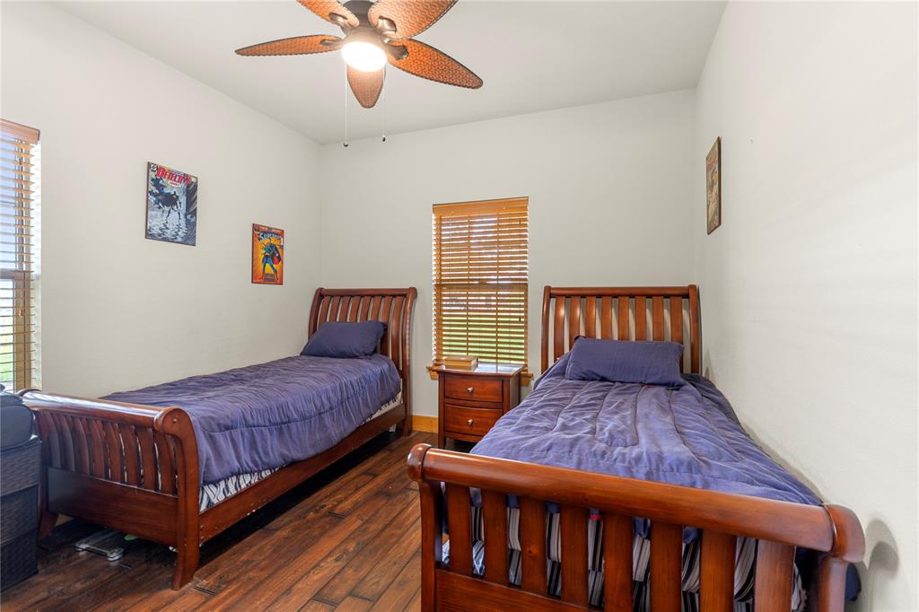 777 Stiles Road Whitesboro, TX 76273 - Photo 16 of 37 a bedroom with two beds and wooden floor