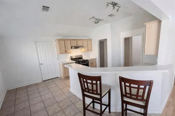 a kitchen with a dining table chairs and cabinets