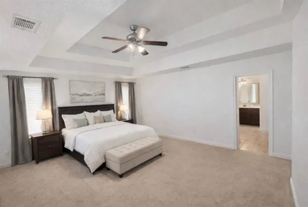 a bedroom with a large bed and a chandelier