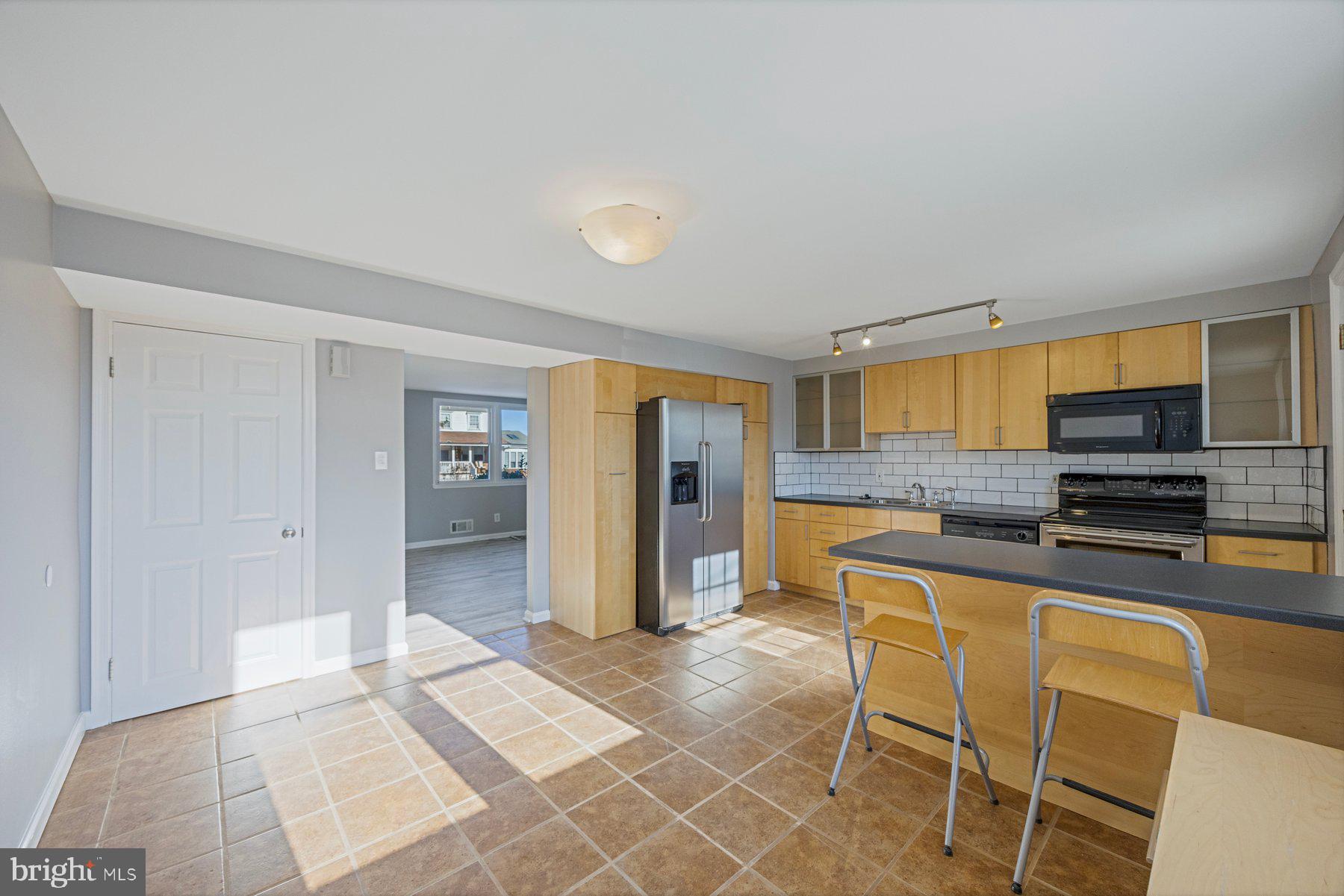 8059 Stratman Road Baltimore, MD 21222 - Photo 10 of 31 a kitchen with stainless steel appliances kitchen island granite countertop a refrigerator and cabinets