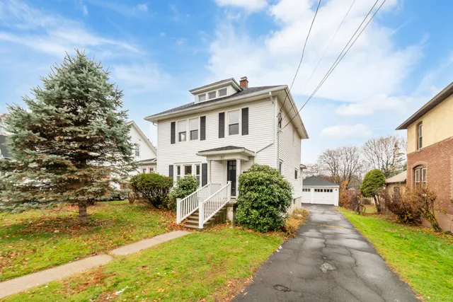 a front view of a house with a garden and plants