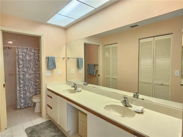 a bathroom with a double vanity sink a mirror and shower