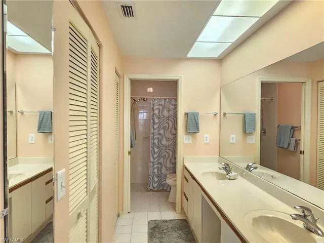 a bathroom with a double vanity sink mirror and shower