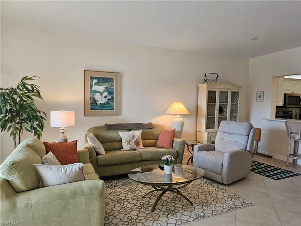 a living room with furniture couches and a dining table with wooden floor