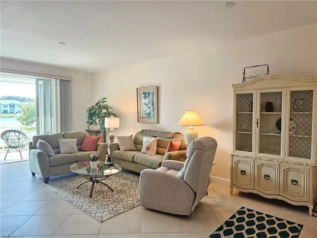 a living room with furniture a lamp a rug and a window