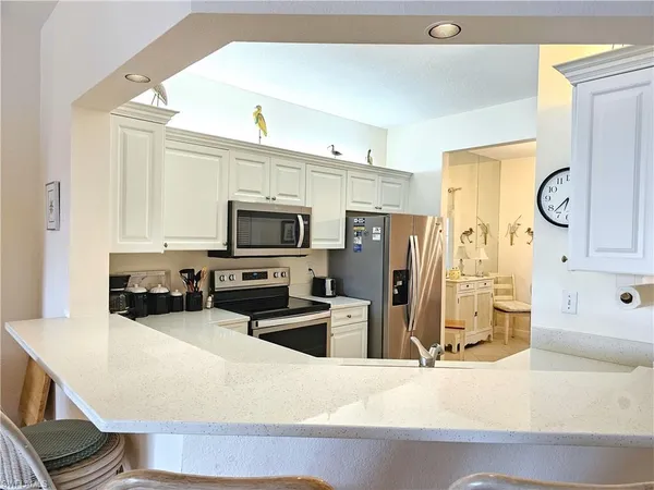 a kitchen with stainless steel appliances granite countertop a refrigerator a stove and a sink with wooden floor