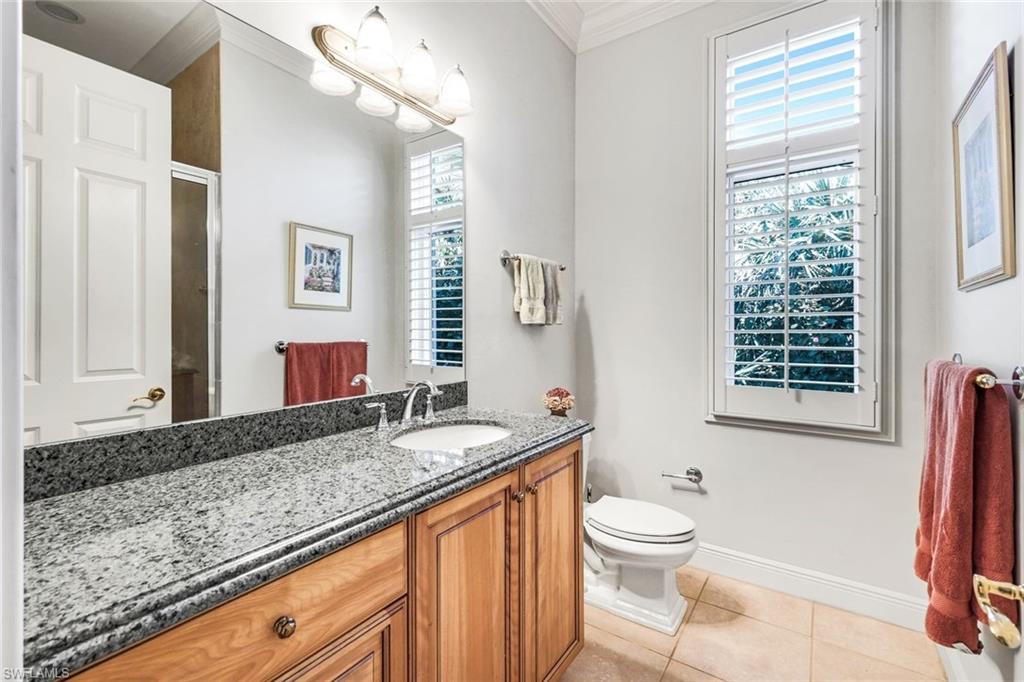 1468 Gormican Lane Naples, FL 34110 - Photo 24 of 36 a bathroom with a granite countertop sink toilet a mirror and a window