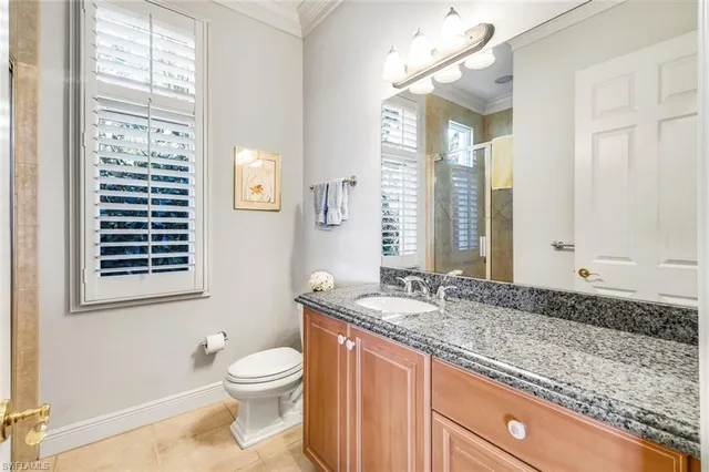 a bathroom with a granite countertop sink toilet and mirror