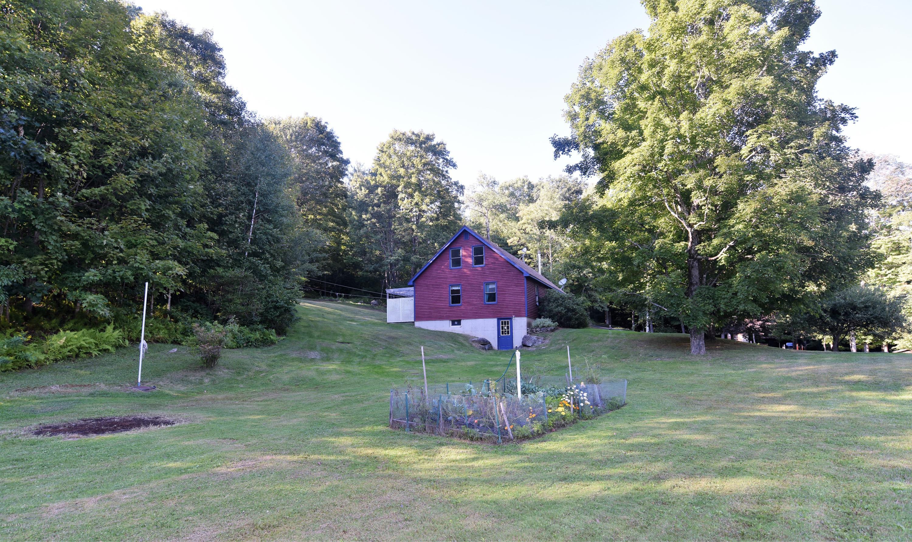 137 West Center Road Otis, MA 01253 - Photo 22 of 27 a view of a house with a yard and sitting area