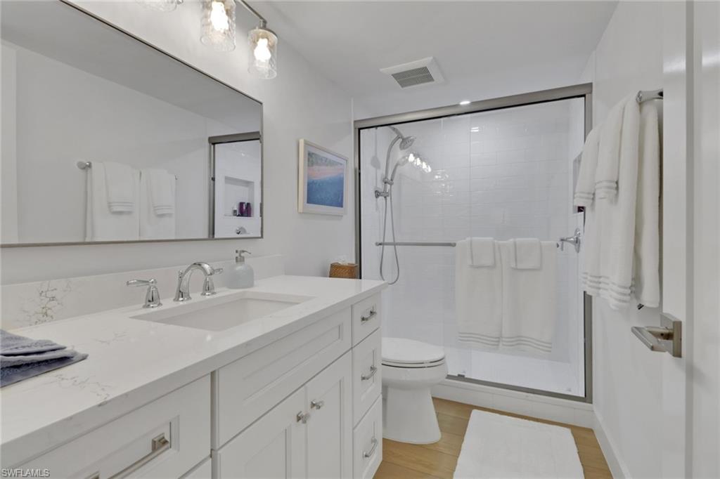 4160 Crayton Road, Unit A4 Naples, FL 34103 - Photo 13 of 23 a bathroom with a sink mirror toilet and shower