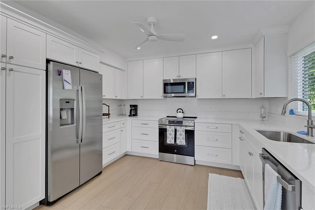 4160 Crayton Road, Unit A4 Naples, FL 34103 - Photo 7 of 23 a kitchen with cabinets stainless steel appliances and a sink