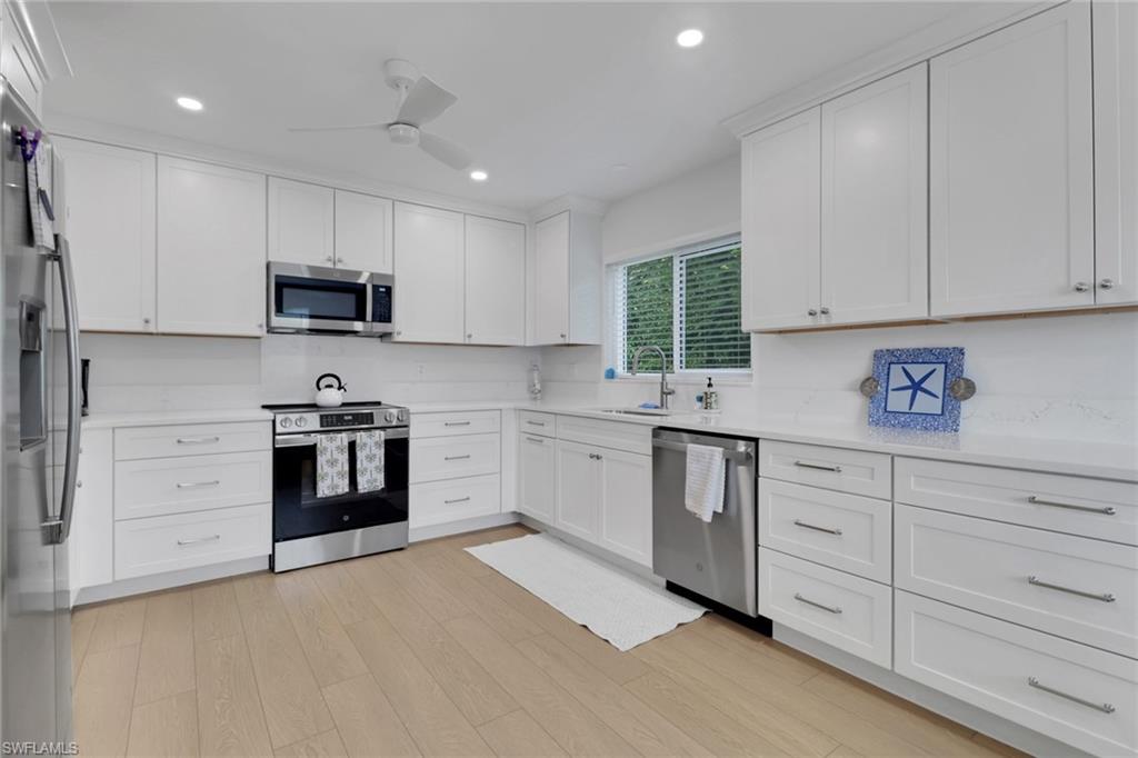 4160 Crayton Road, Unit A4 Naples, FL 34103 - Photo 9 of 23 a kitchen with granite countertop white cabinets and stainless steel appliances