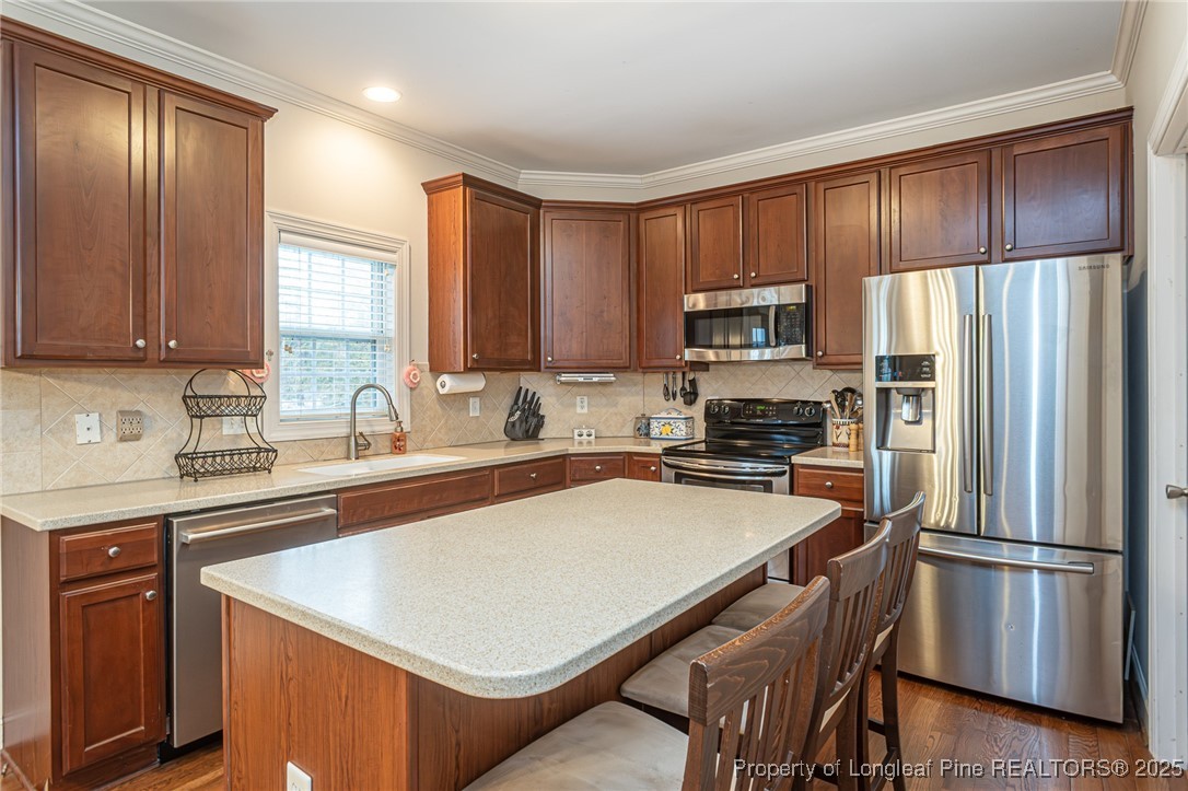 198 Grouse Run Raeford, NC 28376 - Photo 21 of 38 a kitchen with a refrigerator a microwave a sink and cabinets