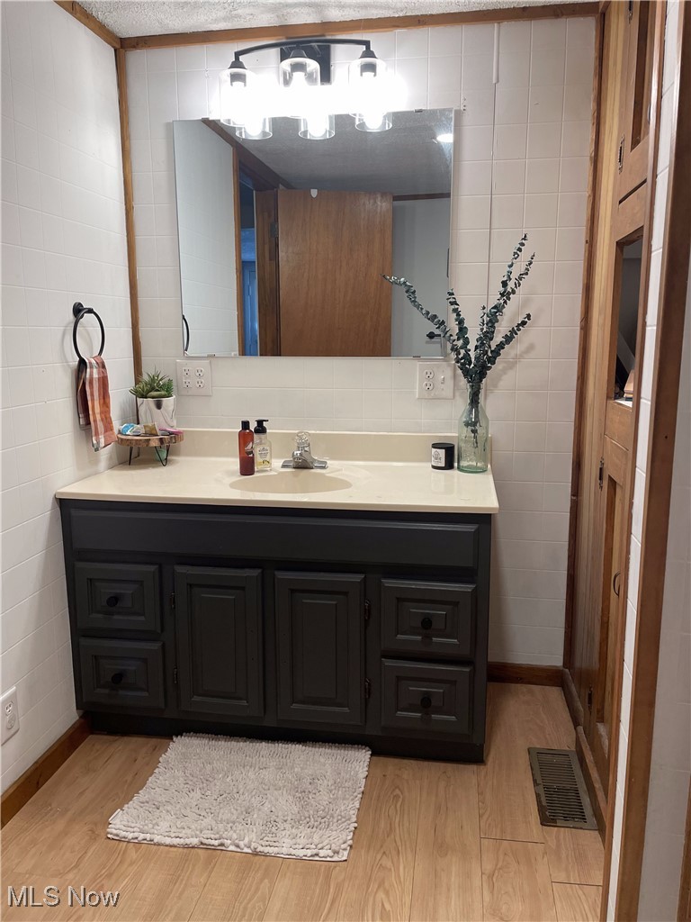 12337 Vincent Road Mount Vernon, OH 43050 - Photo 12 of 34 Bathroom featuring wood-type flooring, vanity, and tile walls