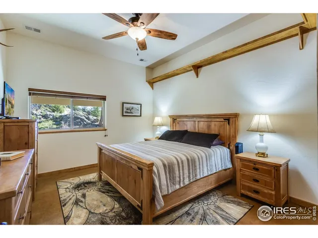 a bedroom with a bed and a flat tv screen on dresser