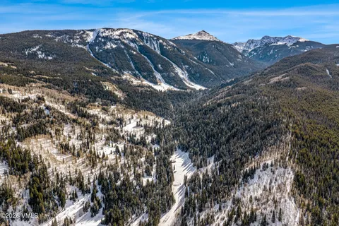 a living room with furniture floor to ceiling window and wooden floor