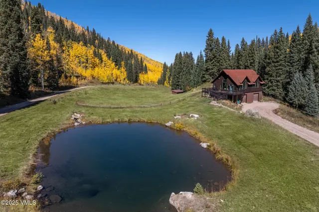 a kitchen with a stove a sink dishwasher a kitchen island with chairs and wooden cabinets