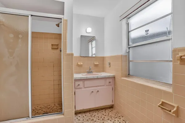 a bathroom with a shower sink and mirror