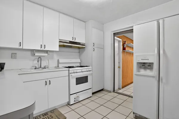 a kitchen with white cabinets and white appliances