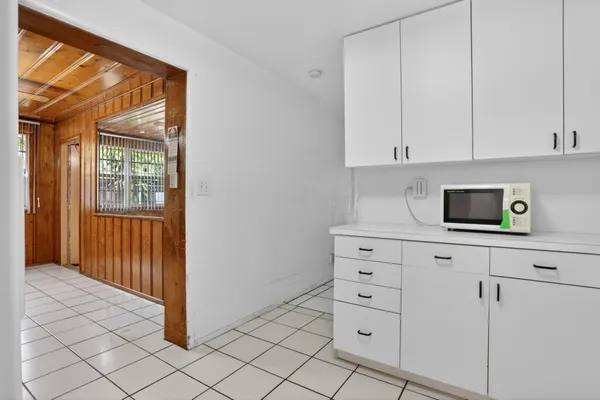 a kitchen with white cabinets and sink