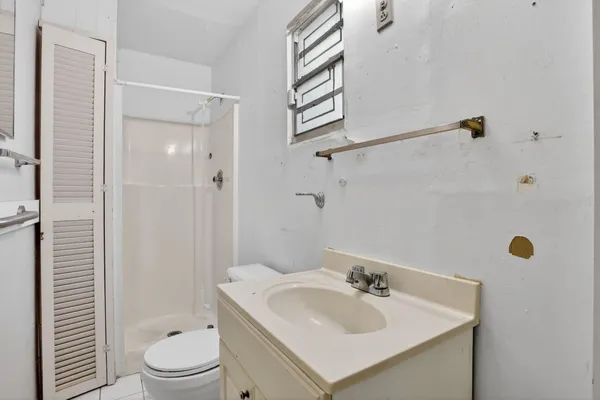 a bathroom with a sink a toilet and shower
