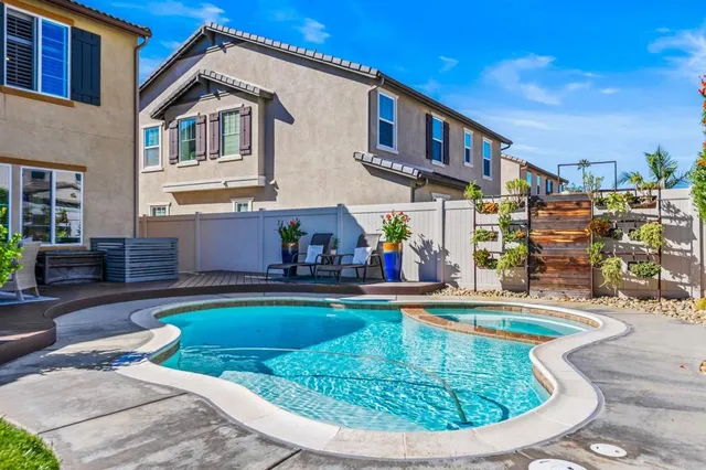 a view of a house with swimming pool and sitting area