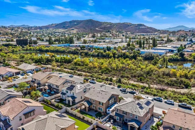 an aerial view of residential houses with outdoor space and trees