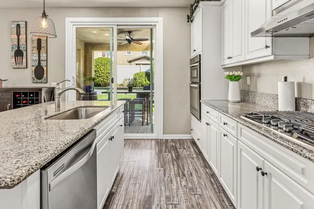 a kitchen with granite countertop a sink stove and refrigerator