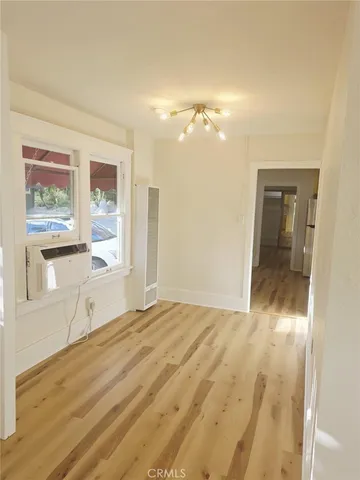 a view of empty room with window and wooden floor