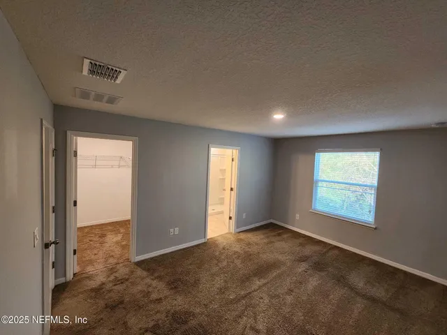 an empty room with windows and closet