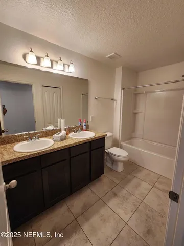 a bathroom with a double vanity sink mirror and toilet