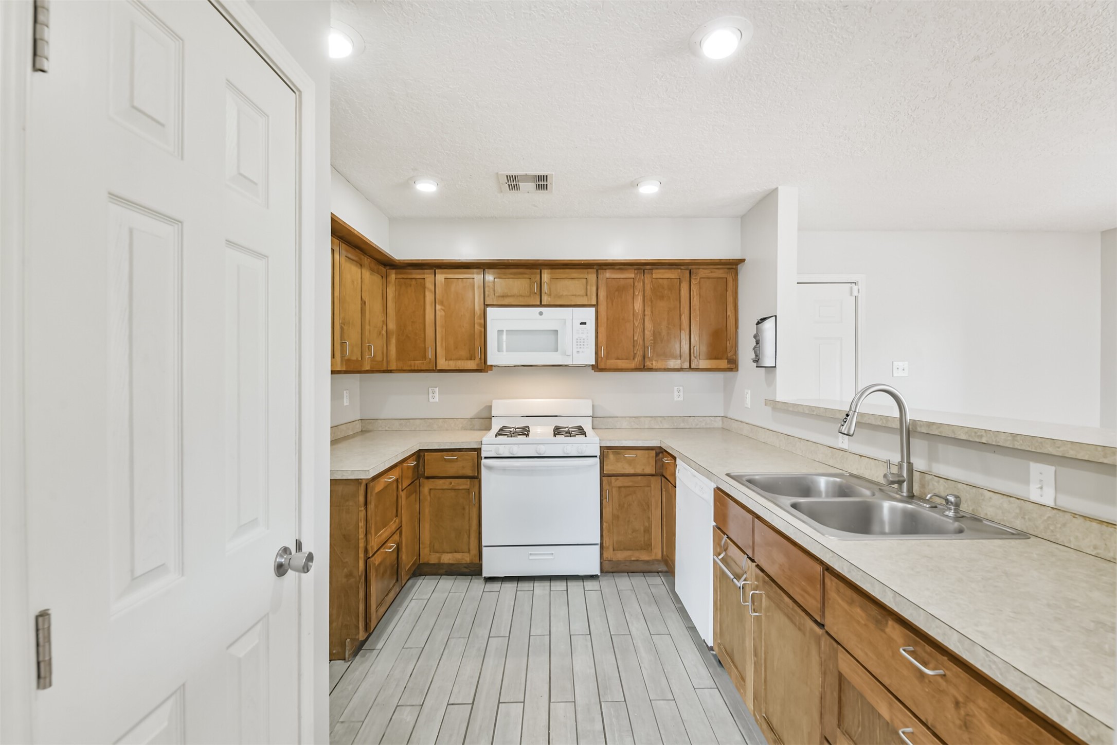 1103 Williams Street Cleveland, TX 77327 - Photo 13 of 32 a kitchen with a sink stove and cabinets