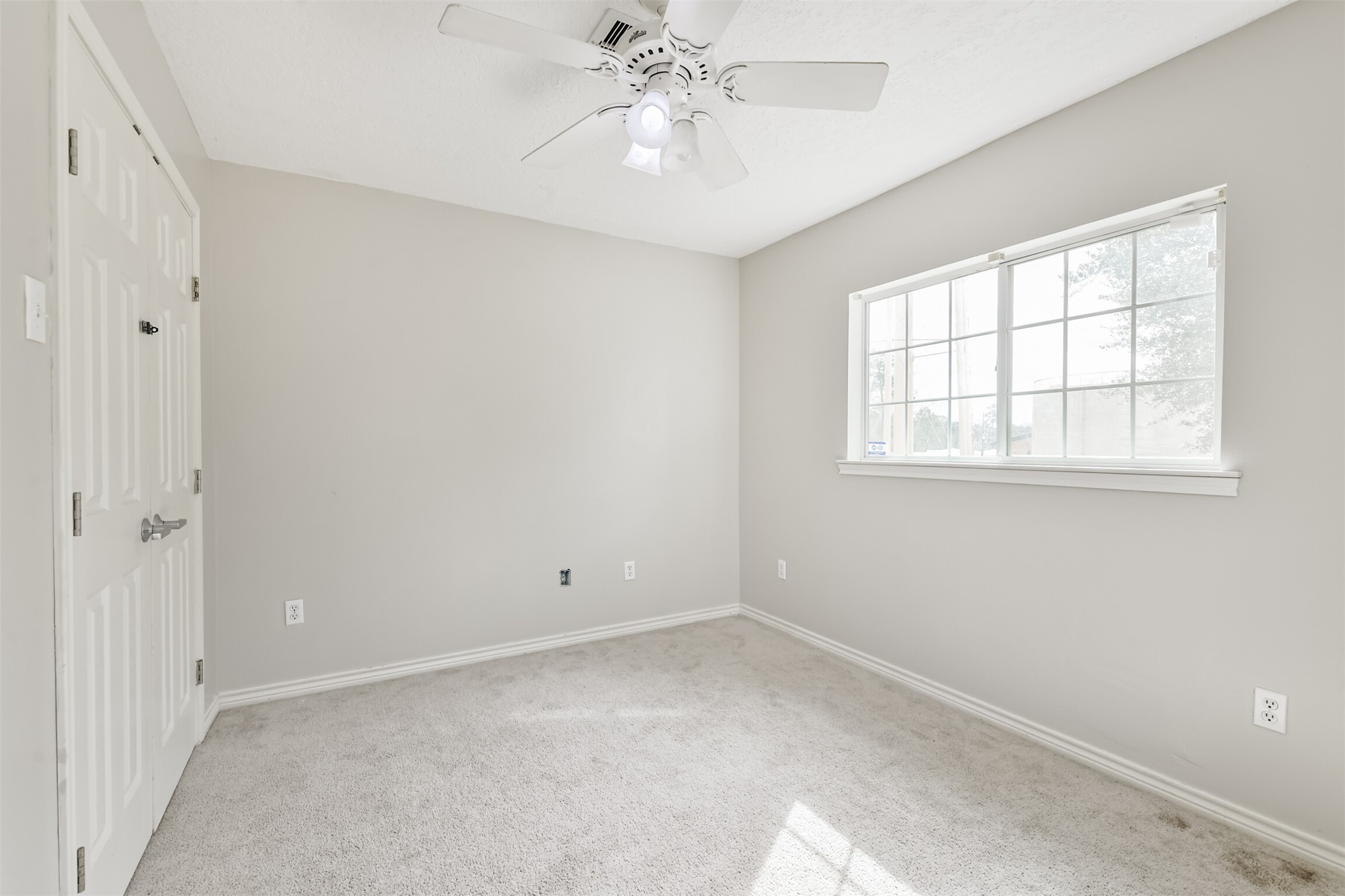 1103 Williams Street Cleveland, TX 77327 - Photo 25 of 32 an empty room with chandelier fan and windows