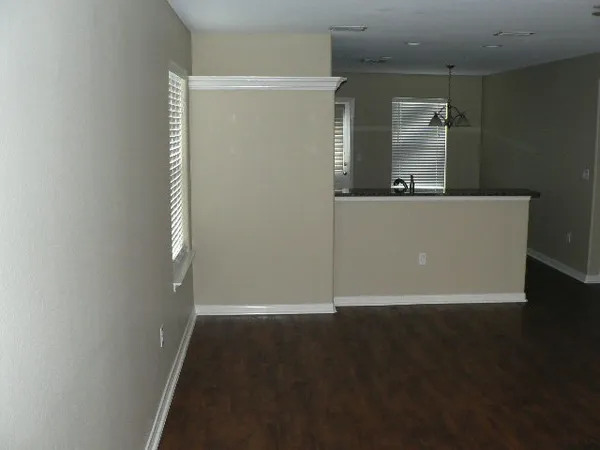 an empty room with wooden floor and a window
