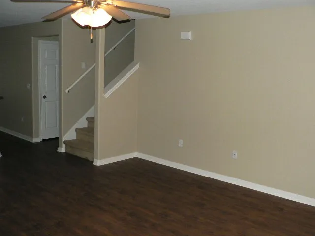 a view of a room with wooden floor and kitchen space