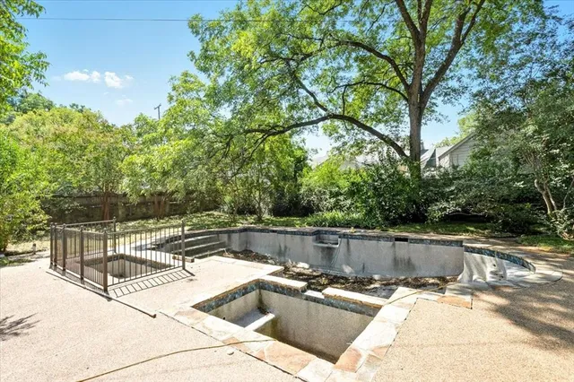 a view of a backyard with a large tree and wooden fence