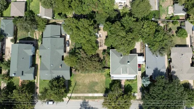 an aerial view of a house with outdoor space and trees all around