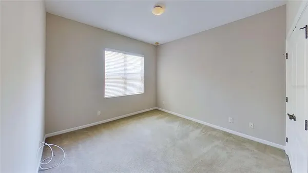 a view of an empty room with wooden floor and a large window