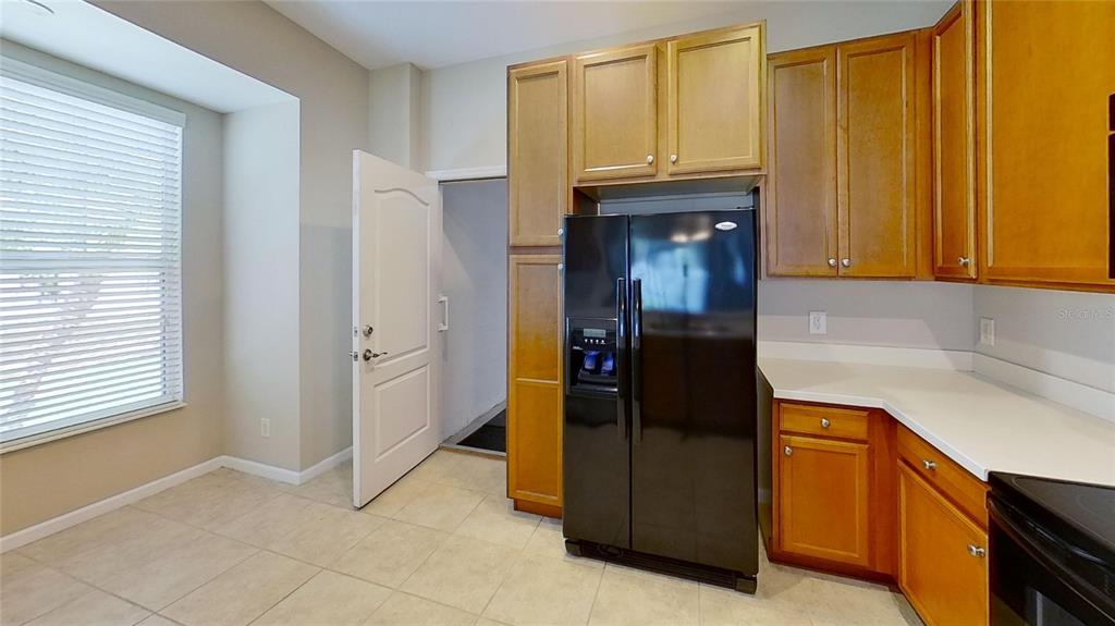 10620 Whittington Court Largo, FL 33771 - Photo 24 of 68 a kitchen with granite countertop cabinets and refrigerator