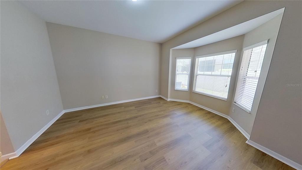 10620 Whittington Court Largo, FL 33771 - Photo 34 of 68 a view of an empty room with wooden floor and a window
