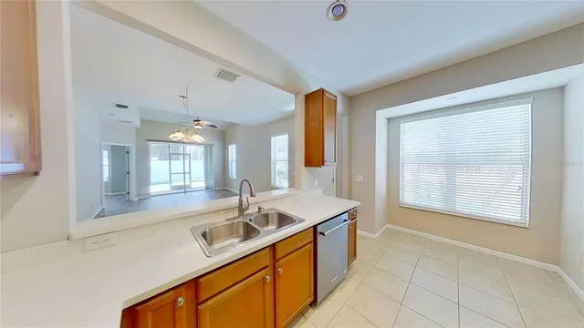 an empty room with windows and chandelier fan